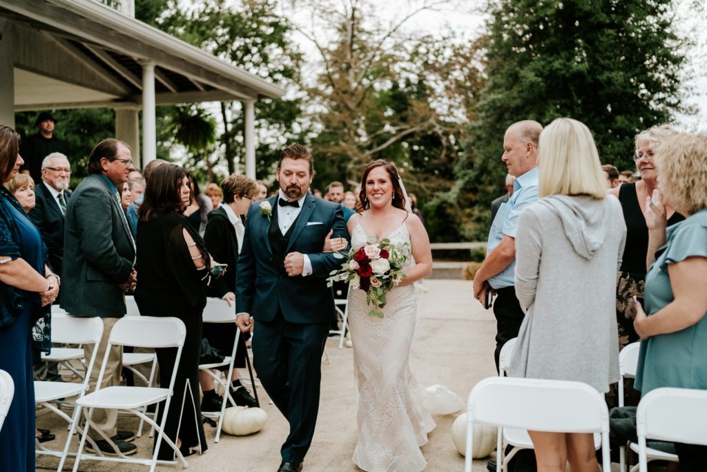 Bride smiles as her dad walks her down the aisle