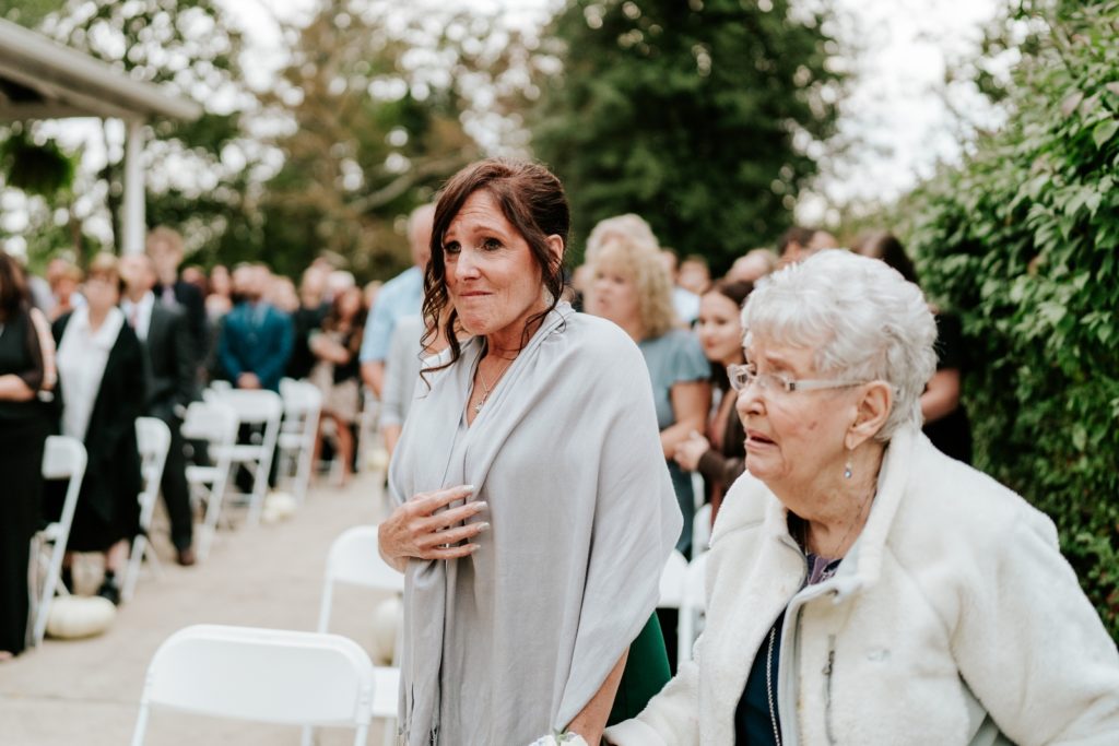 Mom and grandmom are emotional as they watch bride walk down the aisle
