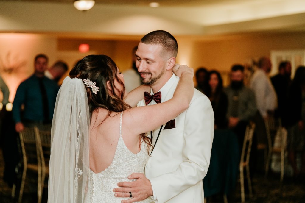 Groom smiles at bride during first dance