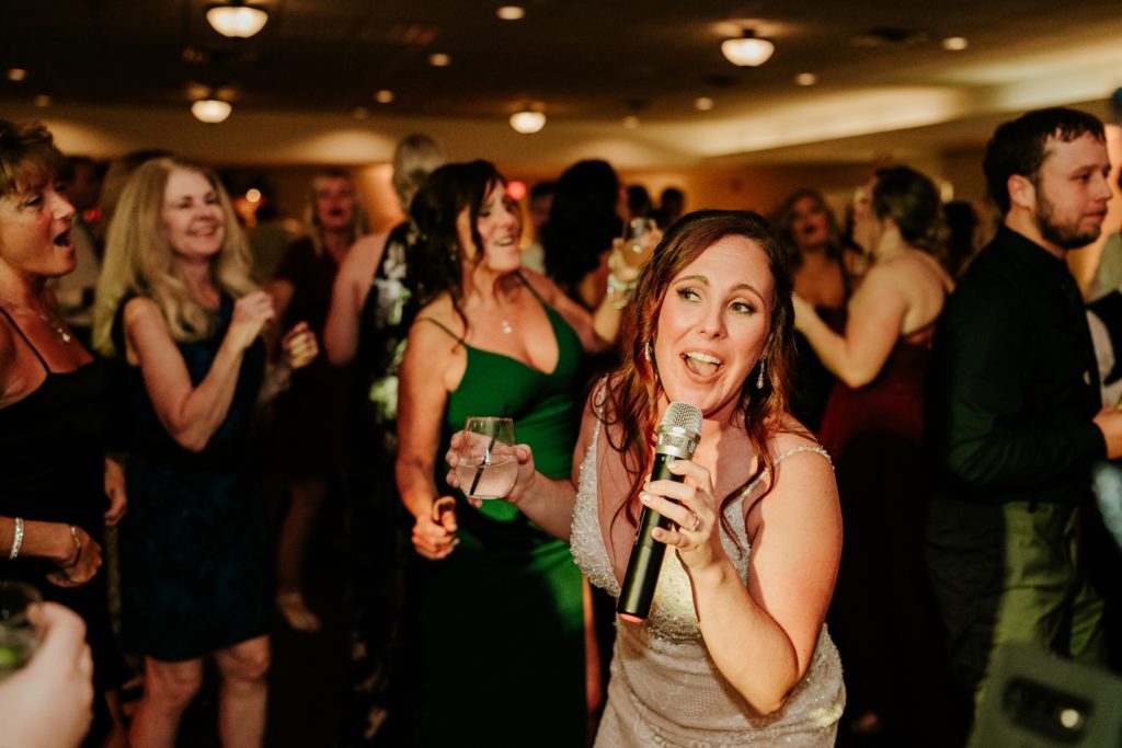 Bride sings into microphone at Bensalem Township Country Club wedding reception
