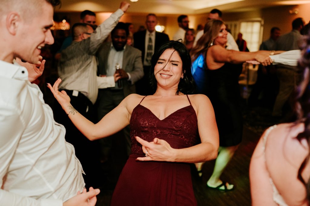 Bridesmaid plays air guitar at wedding reception