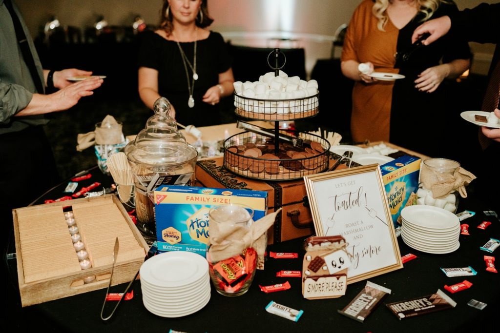 Guests surround smores station at wedding reception