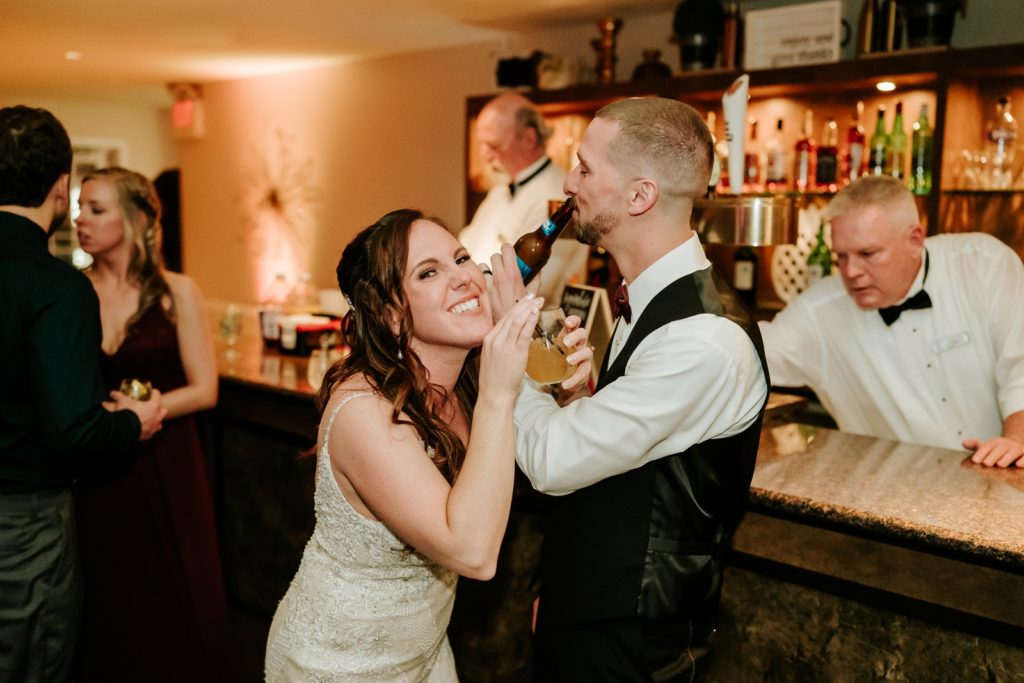 Bride smiles interlocking arms with groom drinking signature cocktails at Bensalem Township Country Club wedding reception