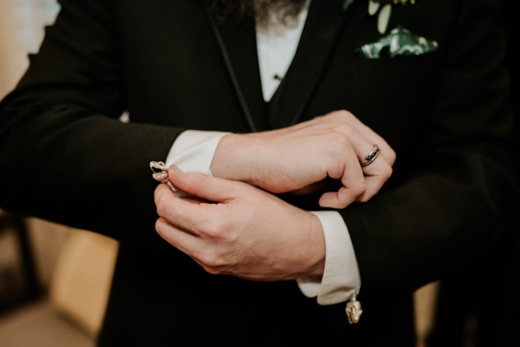 Groom adjusts t-rex dinosaur cufflinks